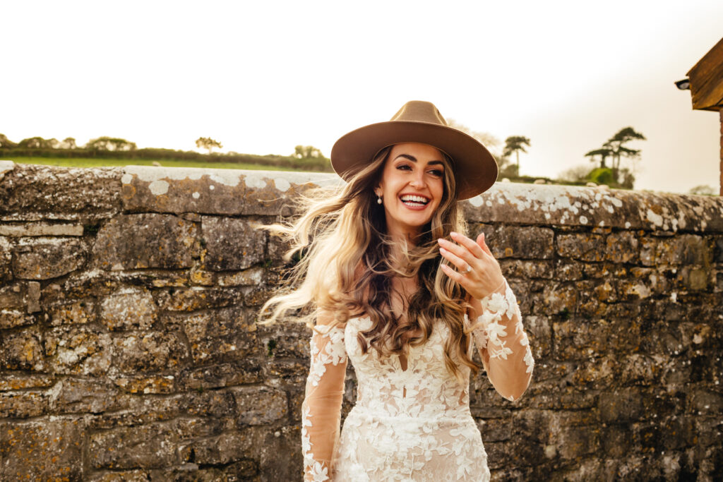 Bride wearing a cowboy hat caught mid laugh, hair flying