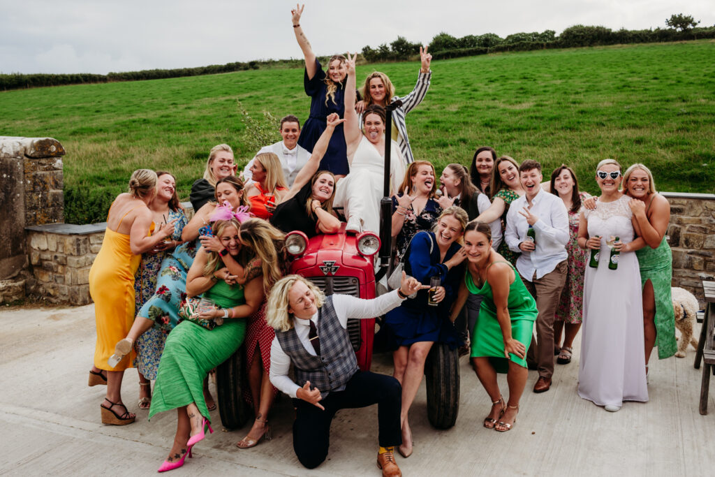 Rosedew Farm Wedding - Fun group photo of bride & bride with 'the rugby girls' on a tractor. 