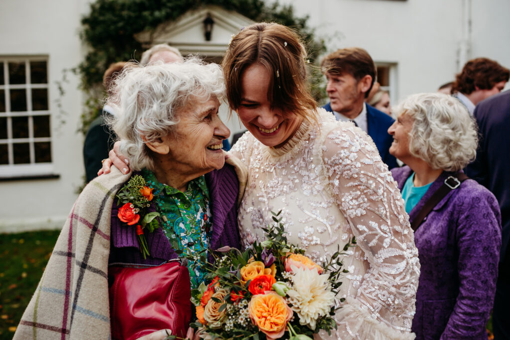 A bride and her grandmother have a happy, warm hug