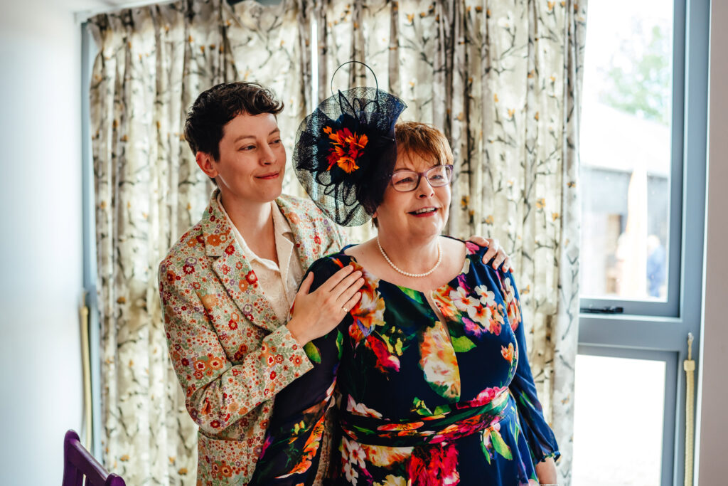 A relaxed photo of a bride in a floral suit with her mum while getting ready