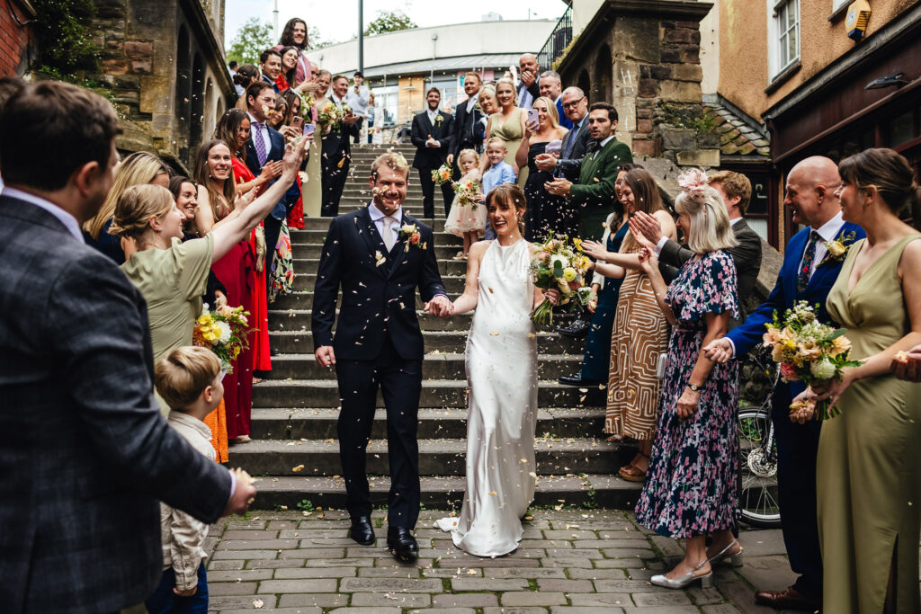 Bride and Groom being showered with confetti by their guests at The Christmas Steps, Bristol