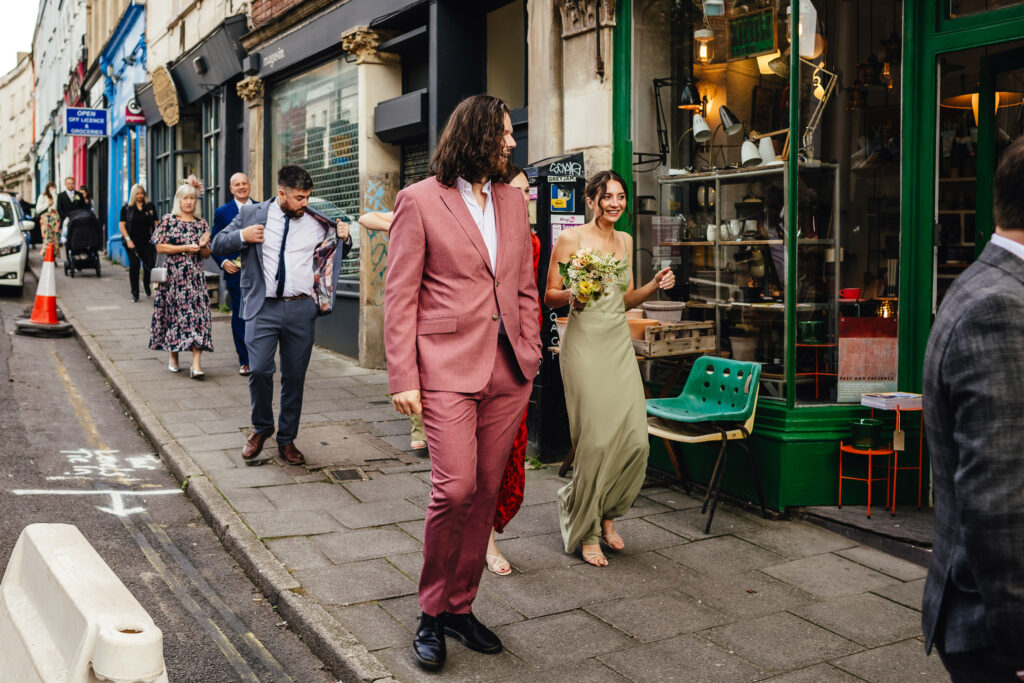 Wedding guests walking down a Bristol Street, ready to throw confetti