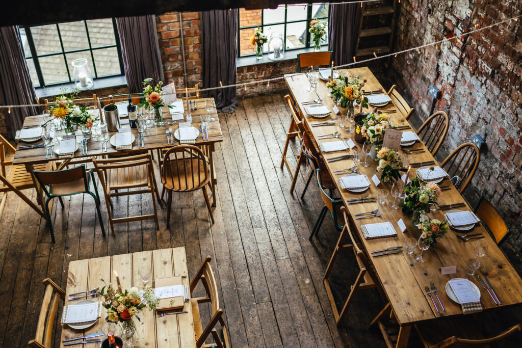 Shot looking down at tables laid out for a wedding breakfast